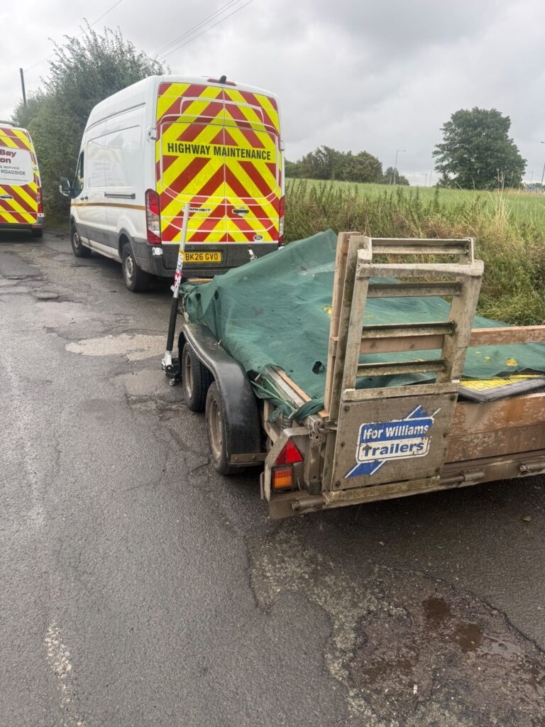 Real roadside trailer tyre call-out near a highway maintenance vehicle