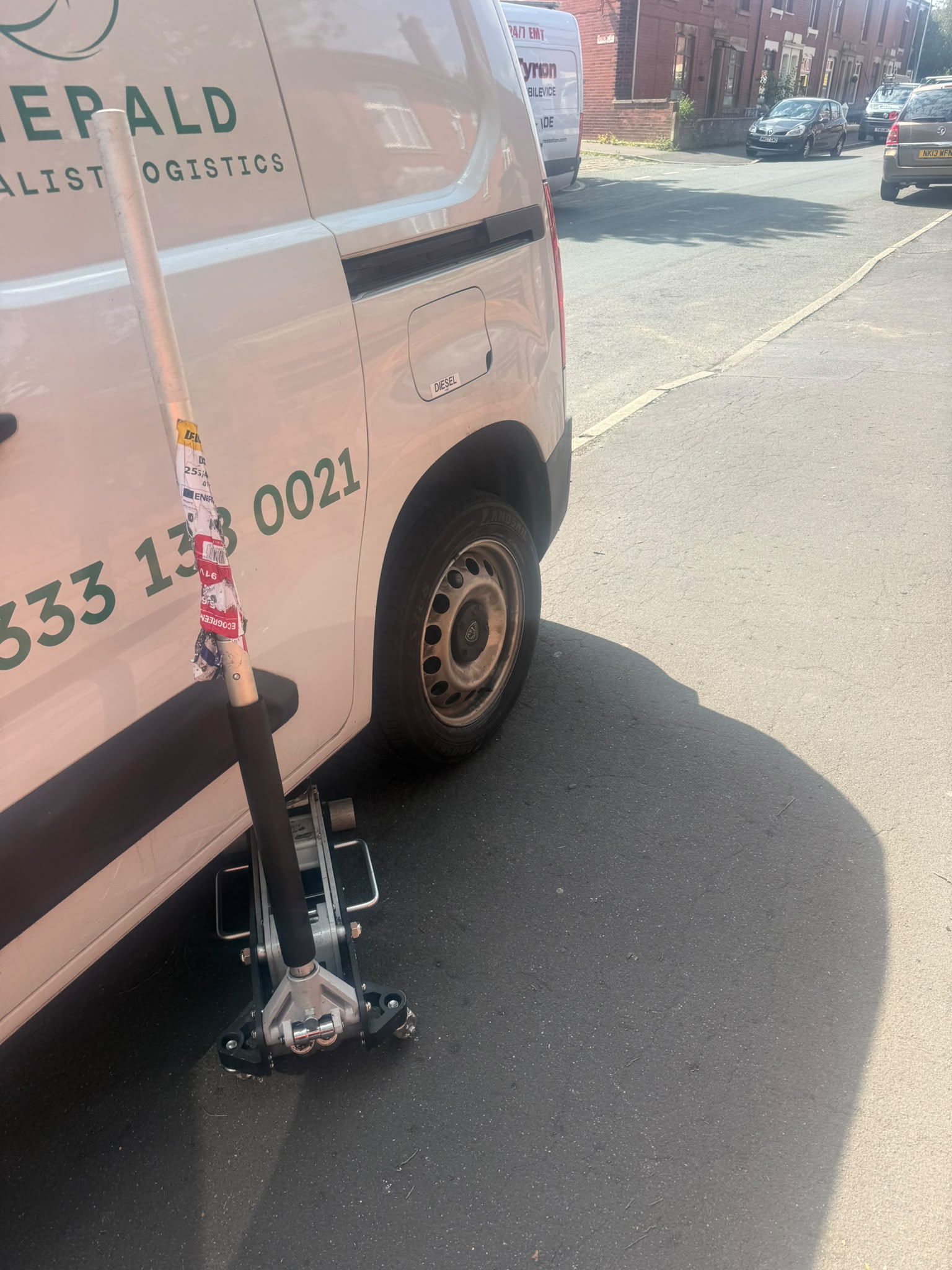 Commercial van raised on a trolley jack during emergency mobile tyre fitting in Bolton