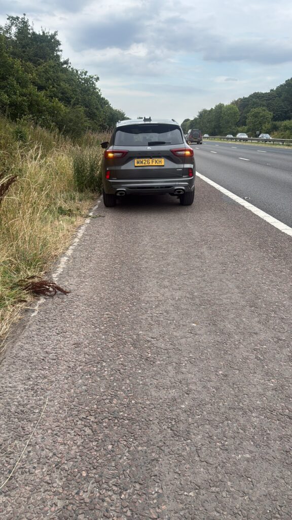 Ford car stopped on a motorway hard shoulder